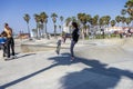 a gorgeous spring landscape at Venice Beach Skatepark at Venice Beach with young men riding skateboards and people watching Royalty Free Stock Photo