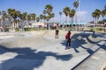 a gorgeous spring landscape at Venice Beach Skatepark at Venice Beach with young men riding skateboards and people watching Royalty Free Stock Photo