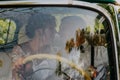 Gorgeous stylish blonde bride posing in retro green car with groom. The bride and groom are sitting inside the retro car Royalty Free Stock Photo