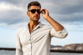 Gorgeous stylish man wearing fashionable shirt and sunglasses. City style Royalty Free Stock Photo