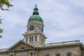 A gorgeous summer landscape at Athens City Hall with a clock tower with a blue dome on top with lush green trees blue sky