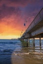 A gorgeous summer landscape at the Belmont Veterans Memorial Pier with blue ocean water and waves rolling into the beach