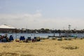 a gorgeous summer landscape at Horny Corner Beach with surfboards along the beach people standing, homes and apartments