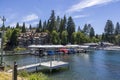 A gorgeous summer landscape at Lake Arrowhead with rippling blue water, boats and yachts docked along the banks, lush green trees