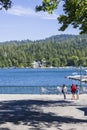 A gorgeous summer landscape at Lake Arrowhead village with boats and yachts sailing on the rippling blue later water, homes