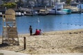 A gorgeous summer landscape at Seabridge Park with a family relaxing in the sand on the beach with boats and yachts in the harbor