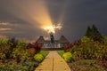 A gorgeous summer landscape with a water fountain with statue of a woman in the center surrounded by colorful flowers Royalty Free Stock Photo