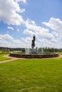 A gorgeous summer landscape with a water fountain with statue of a woman in the center surrounded by colorful flowers Royalty Free Stock Photo