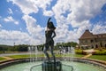 A gorgeous summer landscape with a water fountain with statue of a woman in the center surrounded by colorful flowers Royalty Free Stock Photo