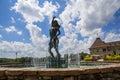 A gorgeous summer landscape with a water fountain with statue of a woman in the center surrounded by colorful flowers Royalty Free Stock Photo