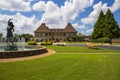 A gorgeous summer landscape with a water fountain with statue of a woman in the center surrounded by colorful flowers Royalty Free Stock Photo