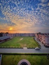 Gorgeous sunset with cumulous clouds over a courtyard with green gras