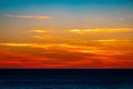 Gorgeous sunset over a dark sea with bright orange clouds in the sky Royalty Free Stock Photo