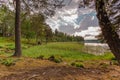 Gorgeous view of beautiful sky reflecting on a mirror of lake surface. Green forest trees bordering the lake on both size. Royalty Free Stock Photo