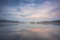 Gorgeous view of fog on sunset on lake on summer day. White clouds on blue sky. Europe. Sweden. Royalty Free Stock Photo