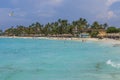 Gorgeous view of hotel private beach. Turquoise ocean warer and white sand beach on green palm trees and blue sky background. Royalty Free Stock Photo