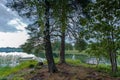 Gorgeous view of sunset on calm summer evening. View of lake with two boats parked in shore, green trees plants reflecting. Royalty Free Stock Photo