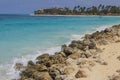 Gorgeous view of turquoise waves of Atlantic Ocean of rocky coast of island of Aruba against backdrop of sandy beach. Royalty Free Stock Photo