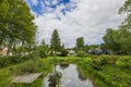 Gorgeous view of villas with forest trees on shore of lake against backdrop of blue sky with white clouds. Royalty Free Stock Photo