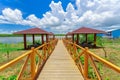 gorgeous view of wooden bridge toward beach gazebos in tropical garden park