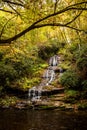 Gorgeous waterfall with fall colored trees on either side in the Great Smoky Mountains National Park, Tennessee, USA. Royalty Free Stock Photo