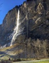 Gorgeous waterfall at famous Lauterbrunnen valley and Swiss Alps with sunlight reflection in winter season Royalty Free Stock Photo