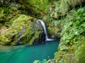 The gorgeous waterfall in Zeleni Vir, Croatia with mossy rocks and sapphire-blue water