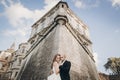 Gorgeous wedding couple embracing in sunlight near old castle in beautiful park. Stylish beautiful bride and groom gently hugging Royalty Free Stock Photo