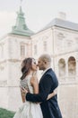 Gorgeous wedding couple embracing in sunlight near old castle in beautiful park. Stylish beautiful bride and groom gently kissing Royalty Free Stock Photo