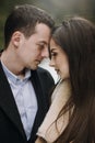 Gorgeous wedding couple gently hugging in winter snowy park. stylish bride in coat and  groom embracing under  trees in winter Royalty Free Stock Photo