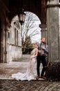 Gorgeous wedding couple hugging and walking near old castle in sunny beautiful park. Stylish beautiful bride and groom posing on Royalty Free Stock Photo