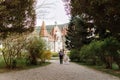 Gorgeous wedding couple hugging and walking near old castle in sunny beautiful park. Stylish beautiful bride and groom posing on Royalty Free Stock Photo