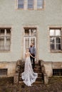 Gorgeous wedding couple hugging and walking near old castle in sunny beautiful park. Stylish beautiful bride and groom posing on Royalty Free Stock Photo