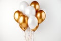 Gorgeous white and gold helium filled balloon shining brightly against a pure white backdrop