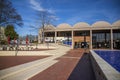 A gorgeous winter landscape at The King Center with a red brick footpath, bare trees, lush green plants and trees