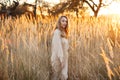 A gorgeous woman in an autumn field illuminated by the warm sun of an evening sunset. Golden ears of corn. Autumn Royalty Free Stock Photo