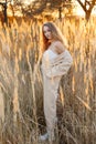 A gorgeous woman in an autumn field illuminated by the warm sun of an evening sunset. Golden ears of corn. Autumn Royalty Free Stock Photo