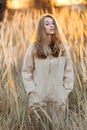 A gorgeous woman in an autumn field illuminated by the warm sun of an evening sunset. Golden ears of corn. Autumn Royalty Free Stock Photo