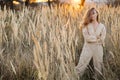 A gorgeous woman in an autumn field illuminated by the warm sun of an evening sunset. Golden ears of corn. Autumn Royalty Free Stock Photo