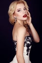 Gorgeous woman with blond hair wears luxurious party dress and bijou Royalty Free Stock Photo