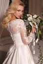 Gorgeous woman with blond hair wears luxurious wedding dress and bijou Royalty Free Stock Photo