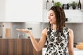 Gorgeous woman, box braids, dress, kitchen backdrop, hand gestur