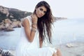 Gorgeous woman with dark hair in elegant dress on beach Royalty Free Stock Photo