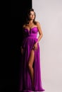 Gorgeous woman in violet dress. Studio picture, grey background