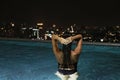 Gorgeous woman in infinity swimming pool on the roof on tall building Royalty Free Stock Photo