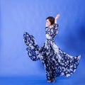 Gorgeous woman with long flying dress on blue background Royalty Free Stock Photo