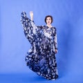 Gorgeous woman with long flying dress on blue background Royalty Free Stock Photo