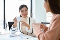 Gorgeous young Asian female boss having a good conversation with her assistant Royalty Free Stock Photo