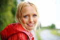 Gorgeous young blonde woman wearing a red raincoat in the rain outdoors on a country road Royalty Free Stock Photo