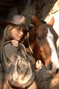 Gorgeous young cowgirl with a horse Royalty Free Stock Photo